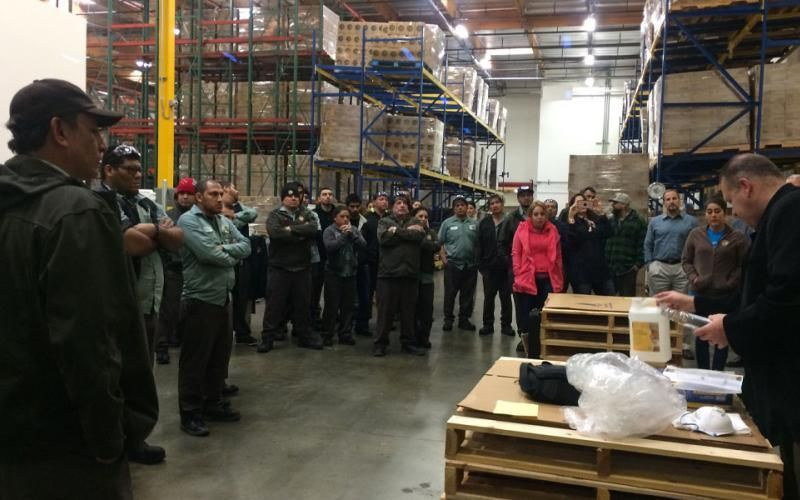 A group of people are standing in a warehouse.