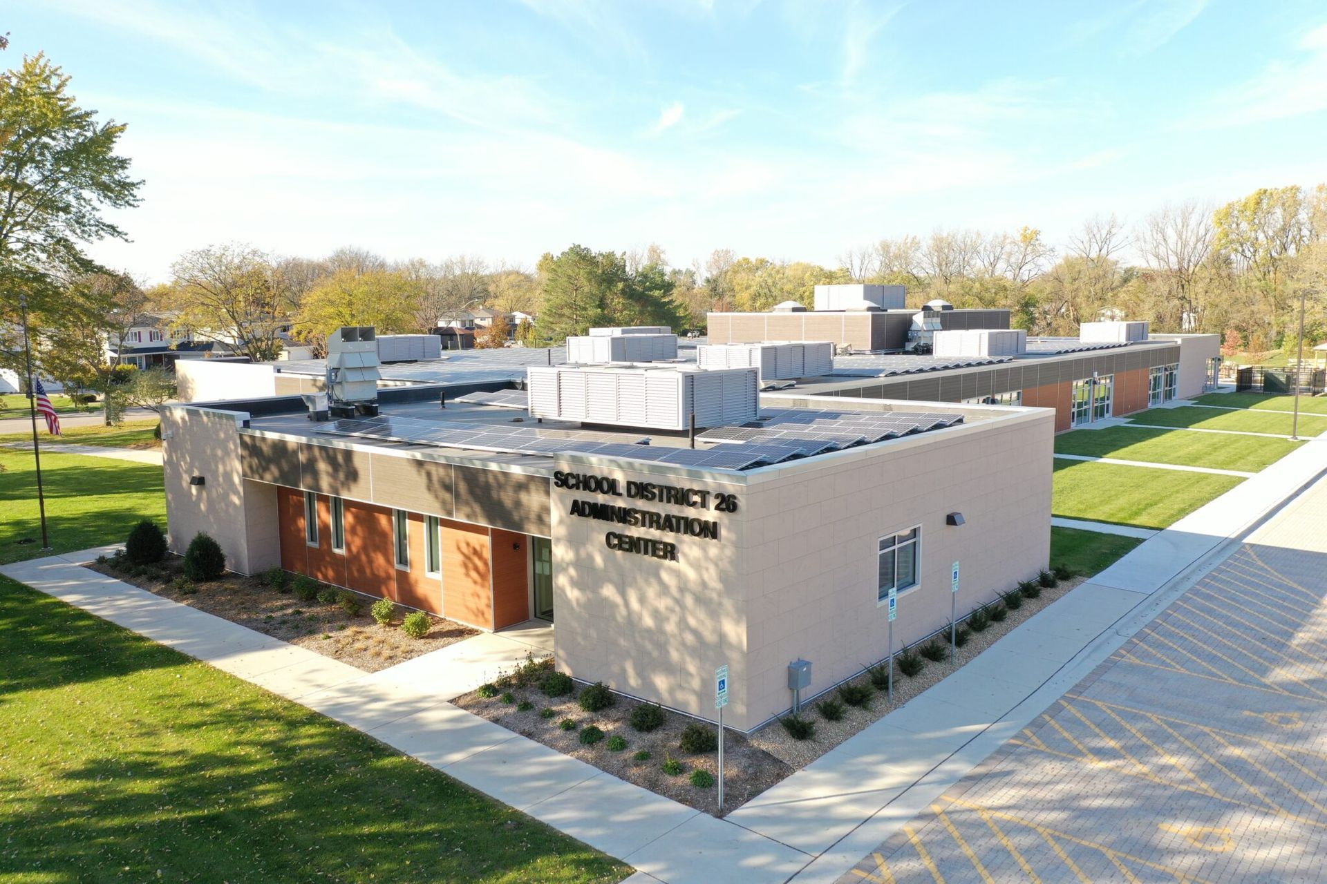 An aerial view of a large building surrounded by grass and trees.