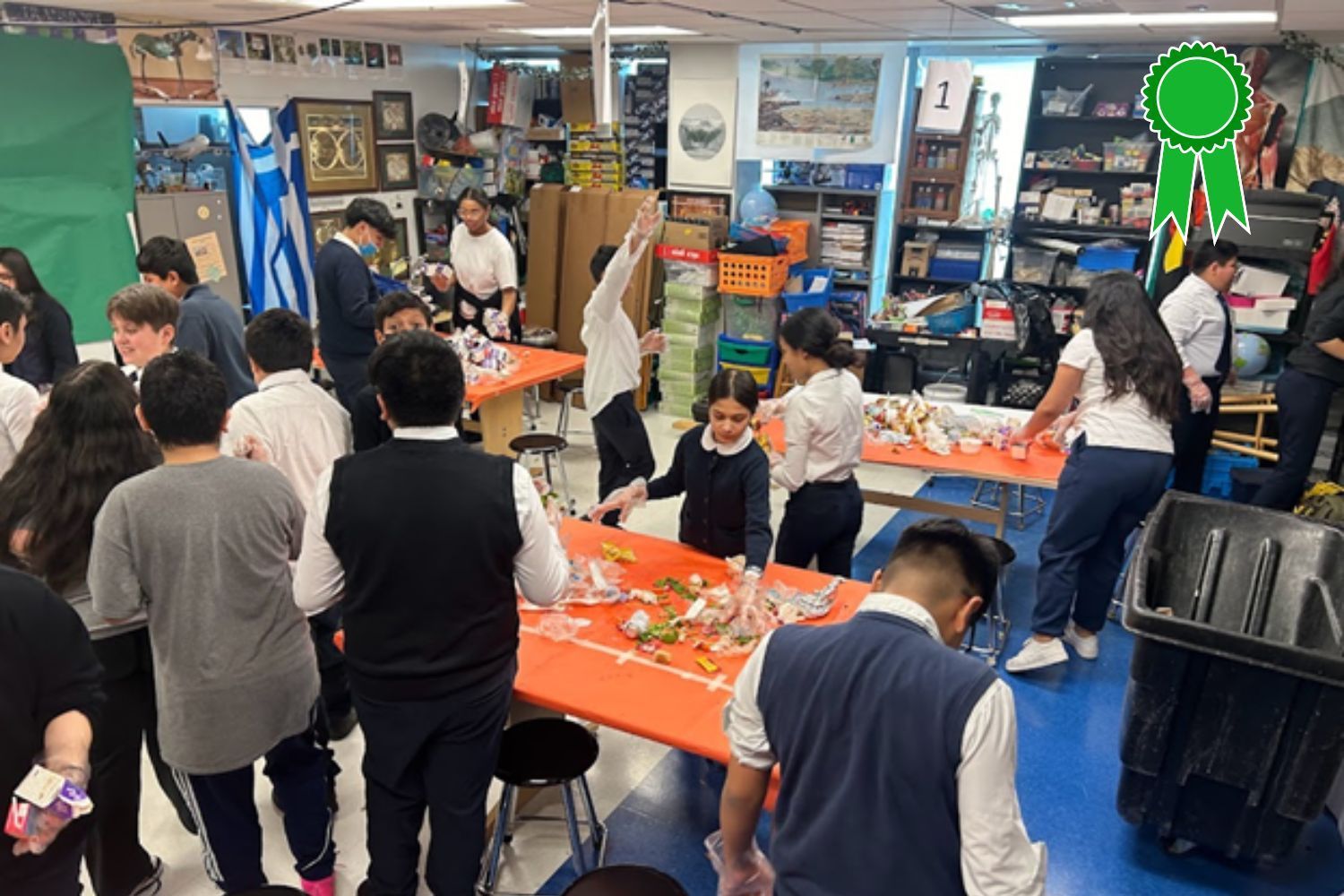 A group of children are standing around tables in a room.