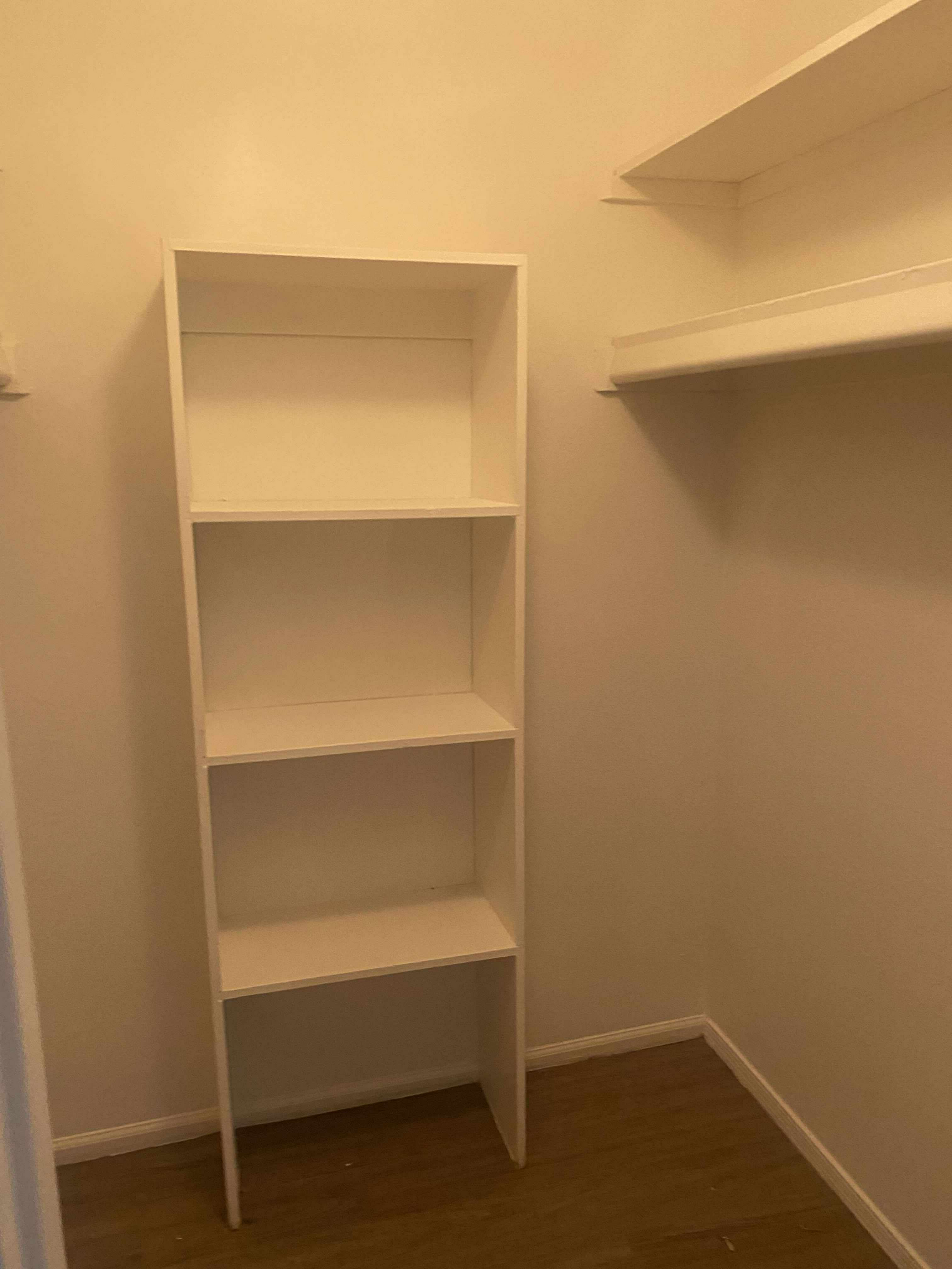 White closet interior with built-in shelves and hanging rack.