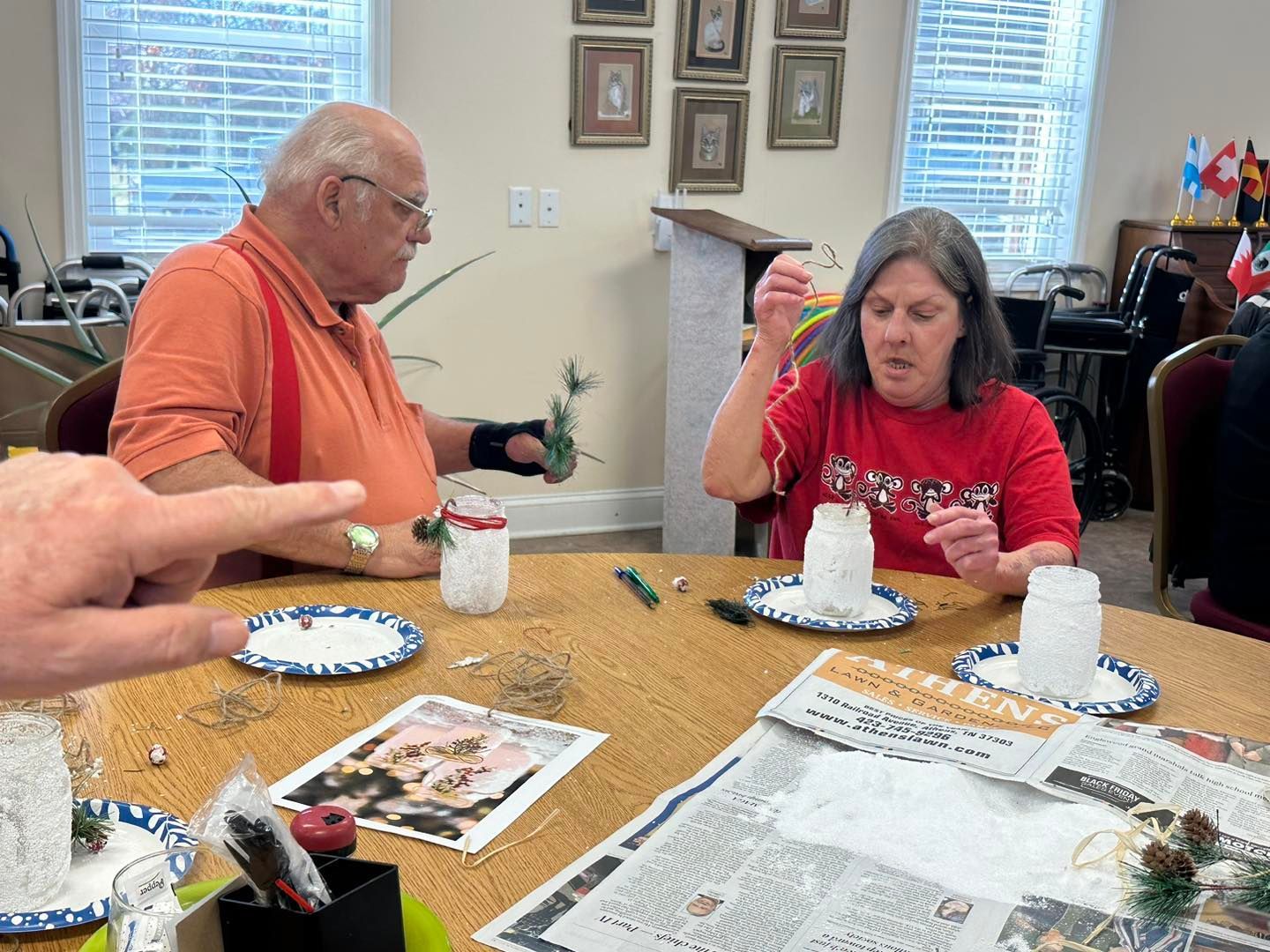 a group of people are sitting around a table making snowmen