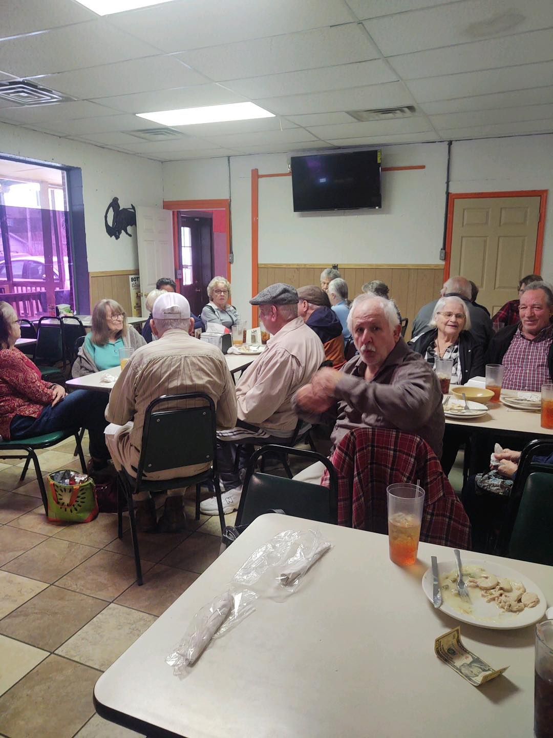 a group of people are sitting at tables in a restaurant