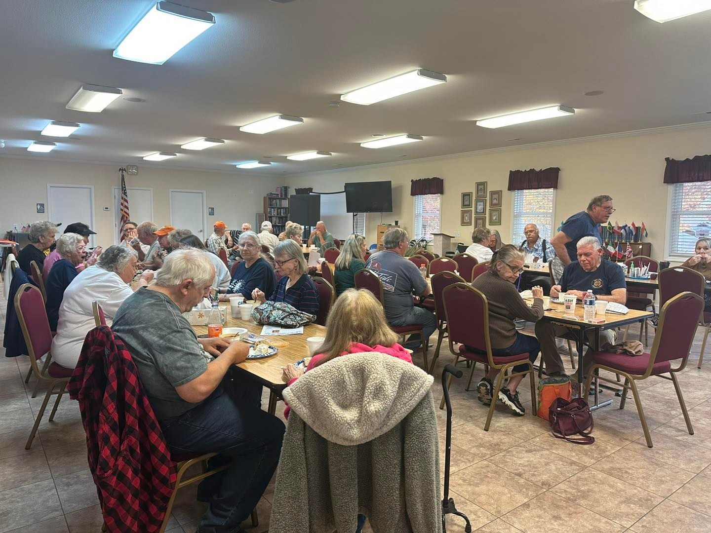 a large group of people are sitting at tables in a large room .