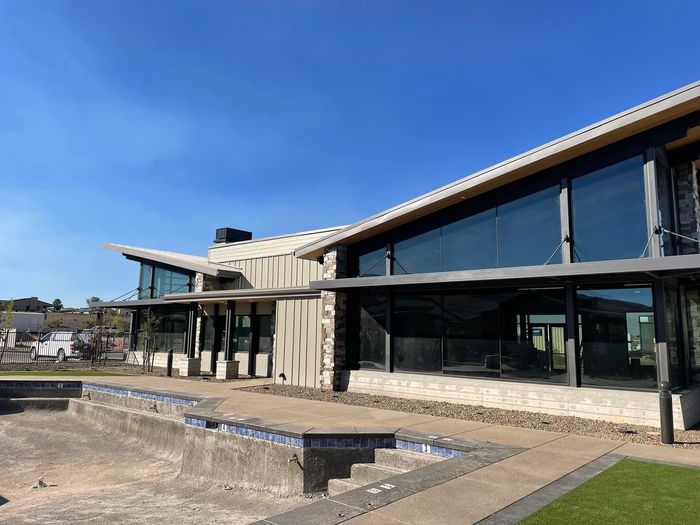 Modern building with large windows and an empty pool on a sunny day.