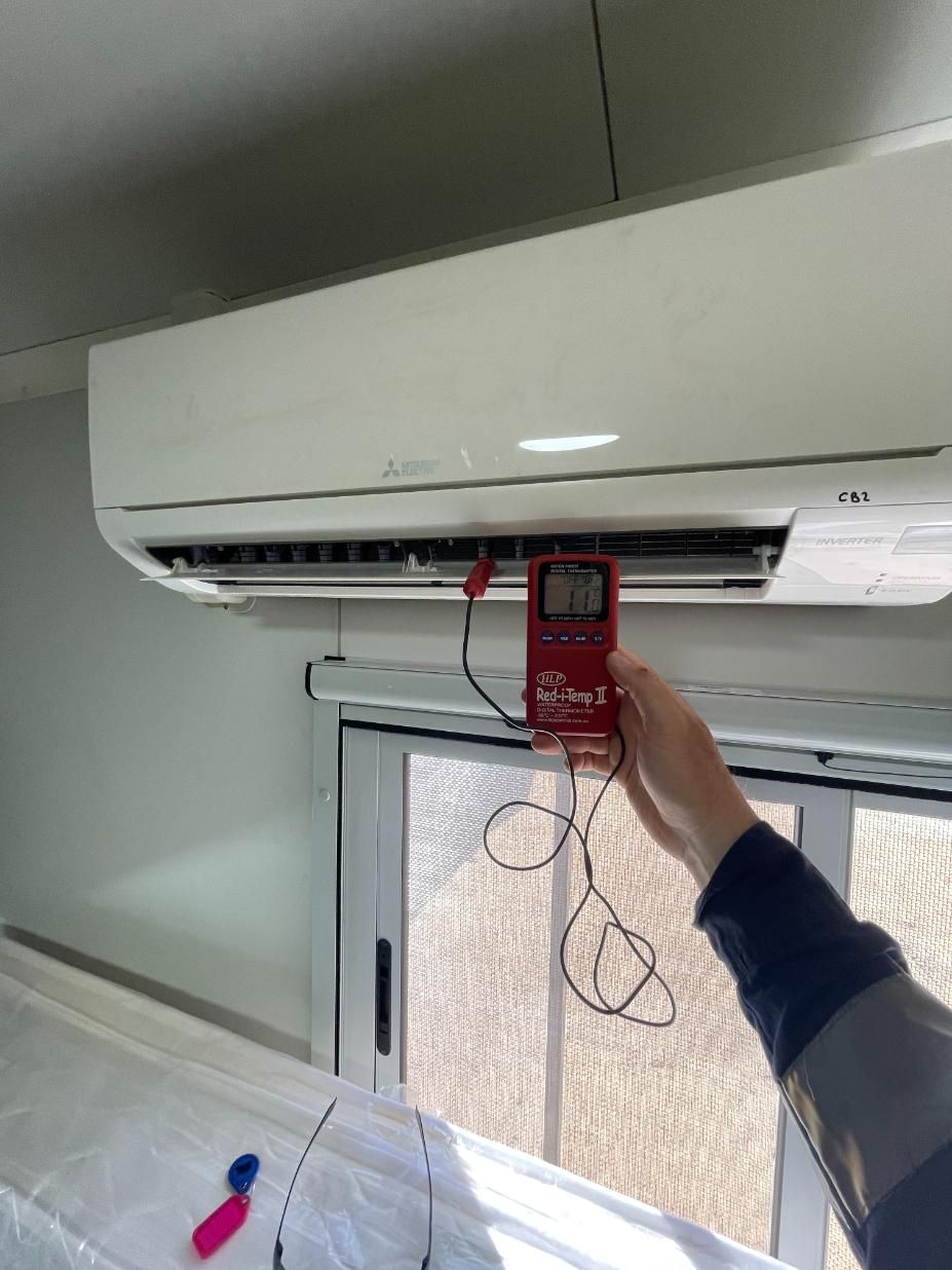 A Person is Measuring the Temperature of an Air Conditioner With a Digital Thermometer — Condie Refrigeration & Air Conditioning In Ballina, NSW