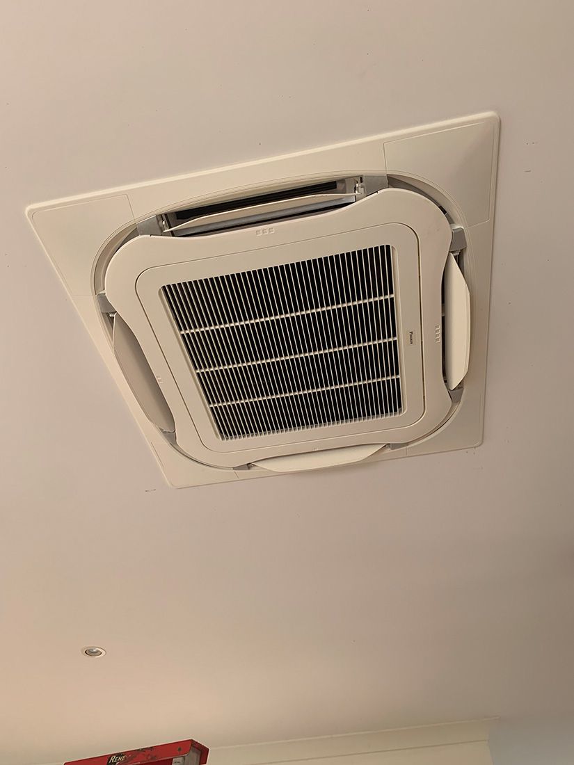 A Square Air Conditioner is Hanging From the Ceiling of a Room — Condie Refrigeration & Airconditioning in Ocean Shores, NSW