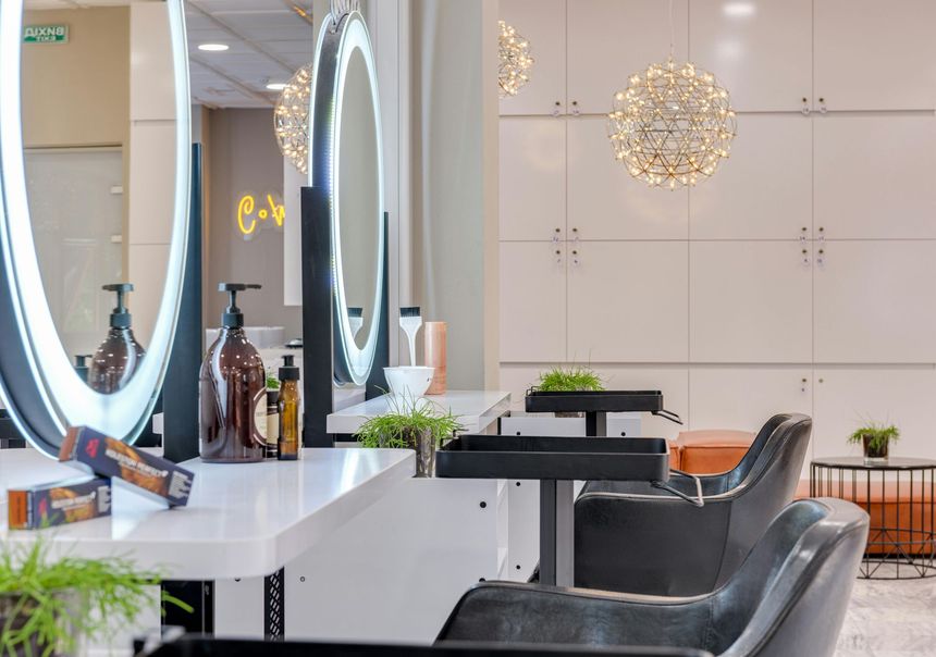 Modern salon interior with styling chairs, mirrors, counters, and decorative pendant lights