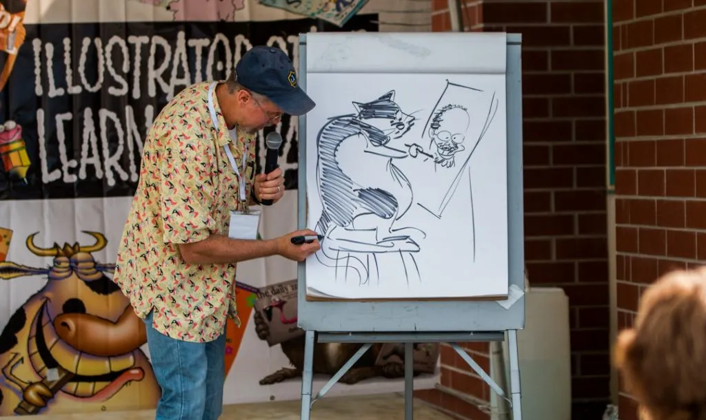 An illustrator demonstrating his illustration skills in front of an audience.