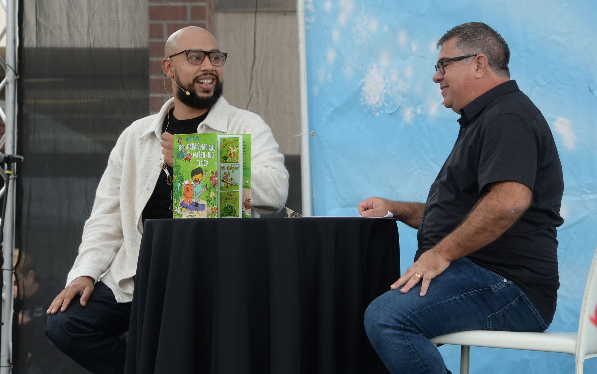 Interviewer talks with a guest author on stage.