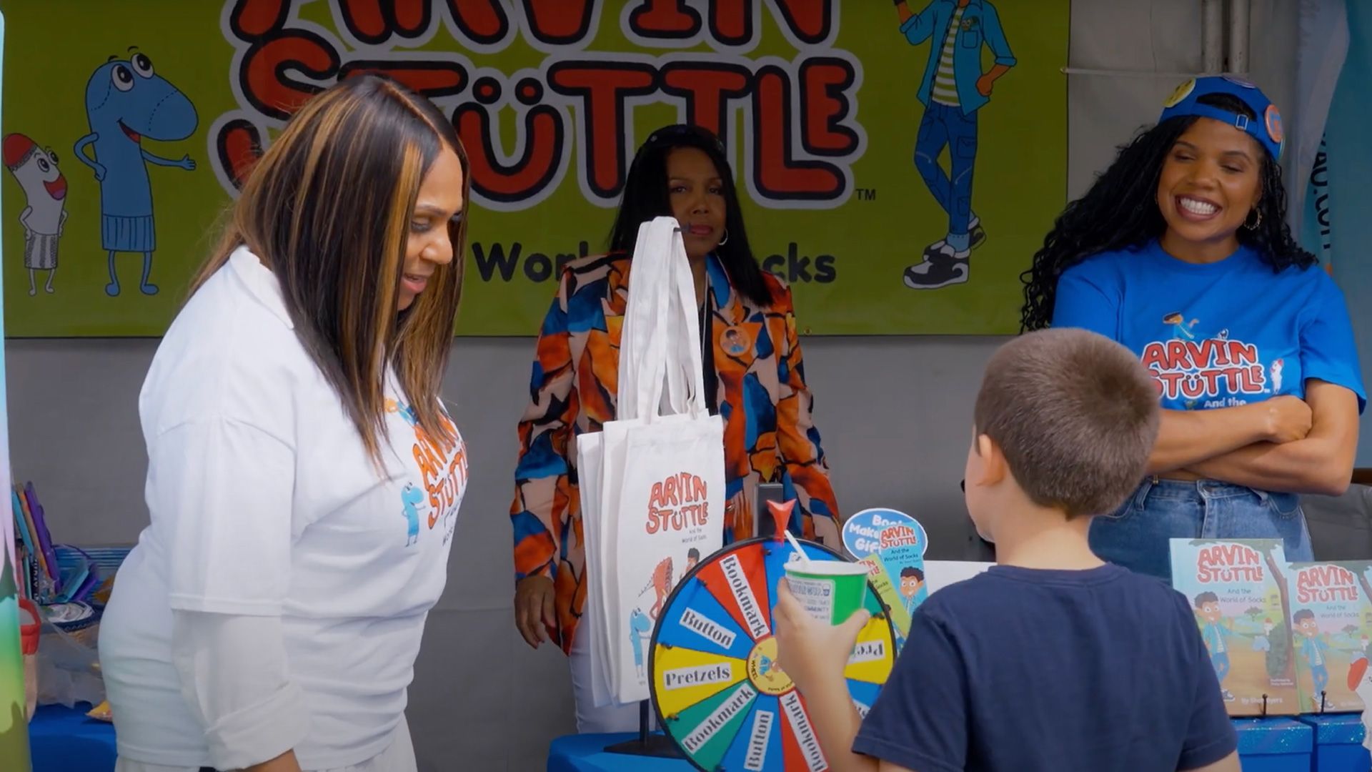 Author Sheri Beyers and two others interact with a young attendee.