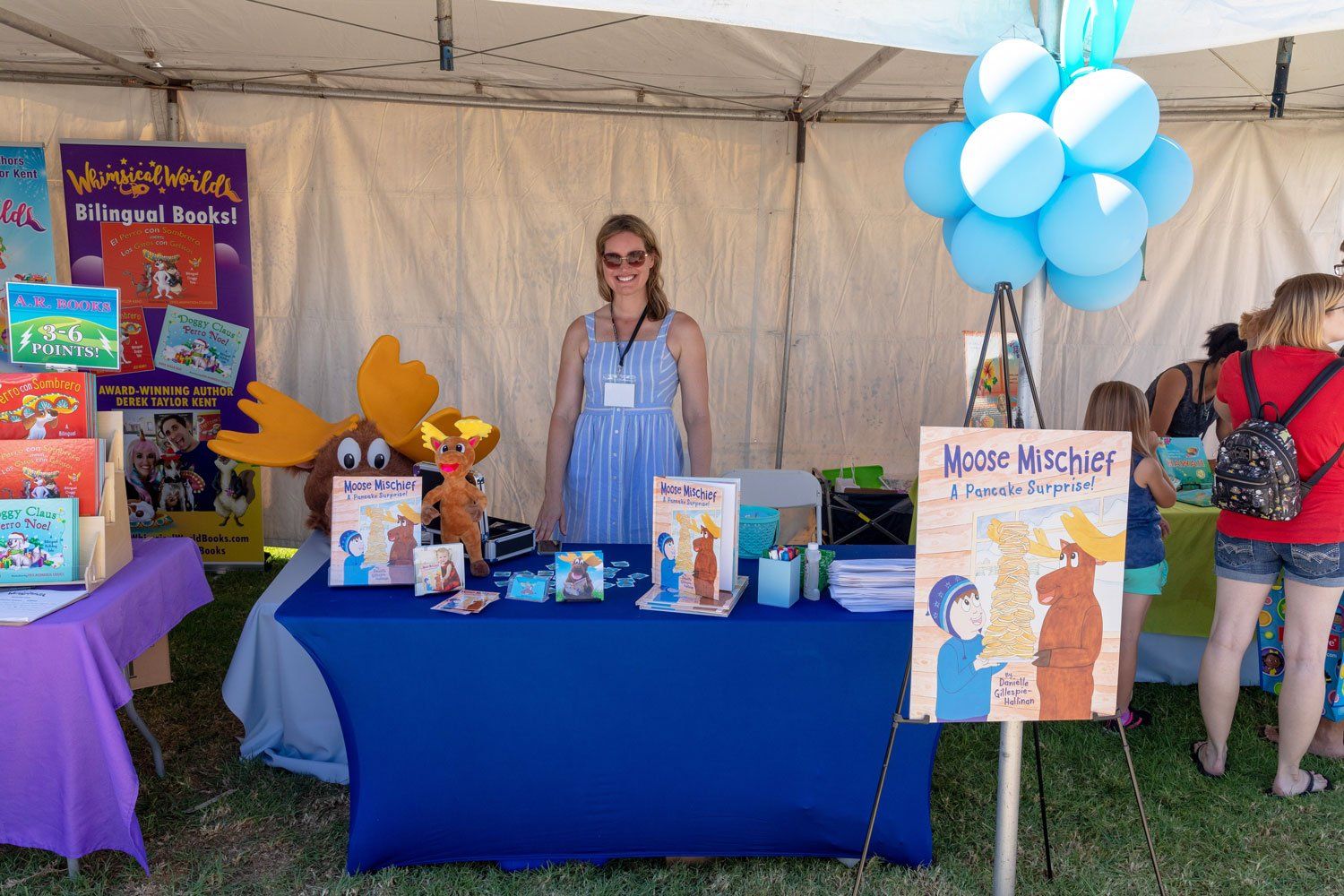 An author stands at her Author's Corner table.