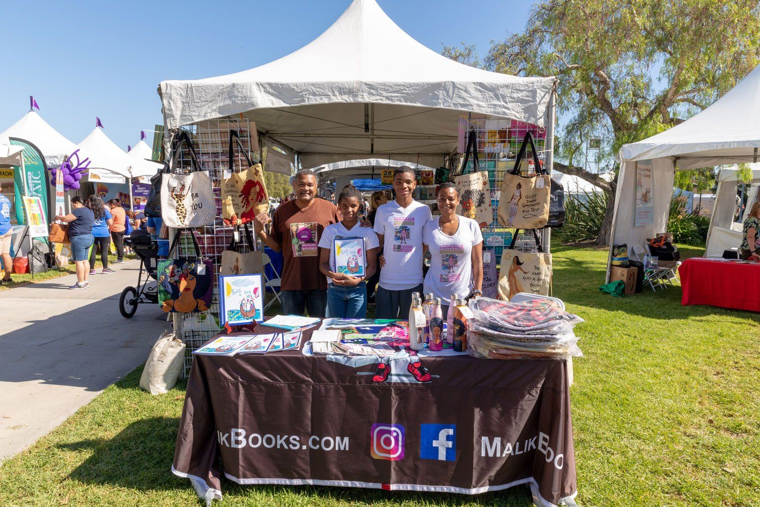 Exhibitors from Maliks Books stand at their booth.