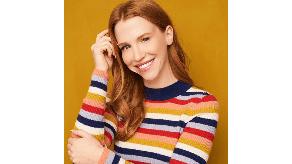 Leslie Stratton smiling and wearing a colorful striped sweater.