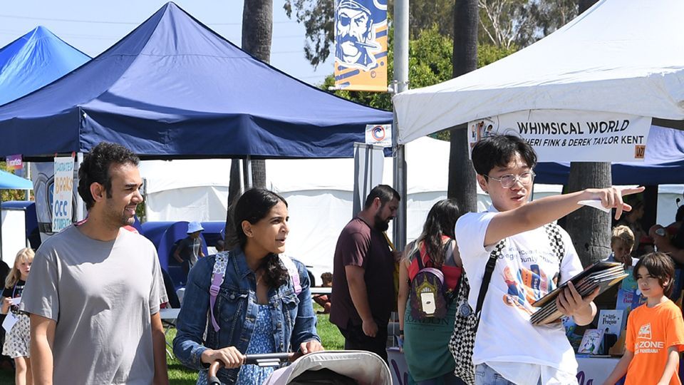 Volunteer helps a family at the Festival.