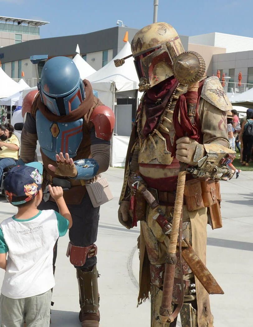 Young child interacts with two Star Wars characters.