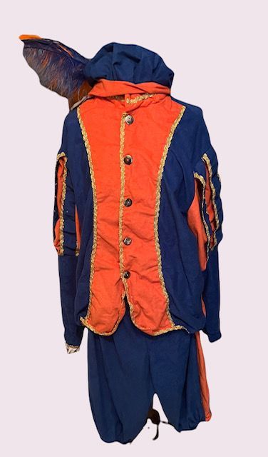 Oranje en marineblauwe outfit met capuchon, knoopsluiting aan de voorkant en loshangende blauwe broek op een paspop