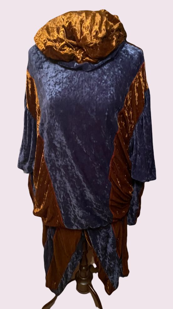 Blauw en goudkleurig kostuum met capuchon op een paspop, van achteren gezien.