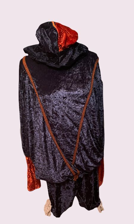 Glanzend zwart kostuum met capuchon en rood-oranje accenten, vooraanzicht op een effen achtergrond.