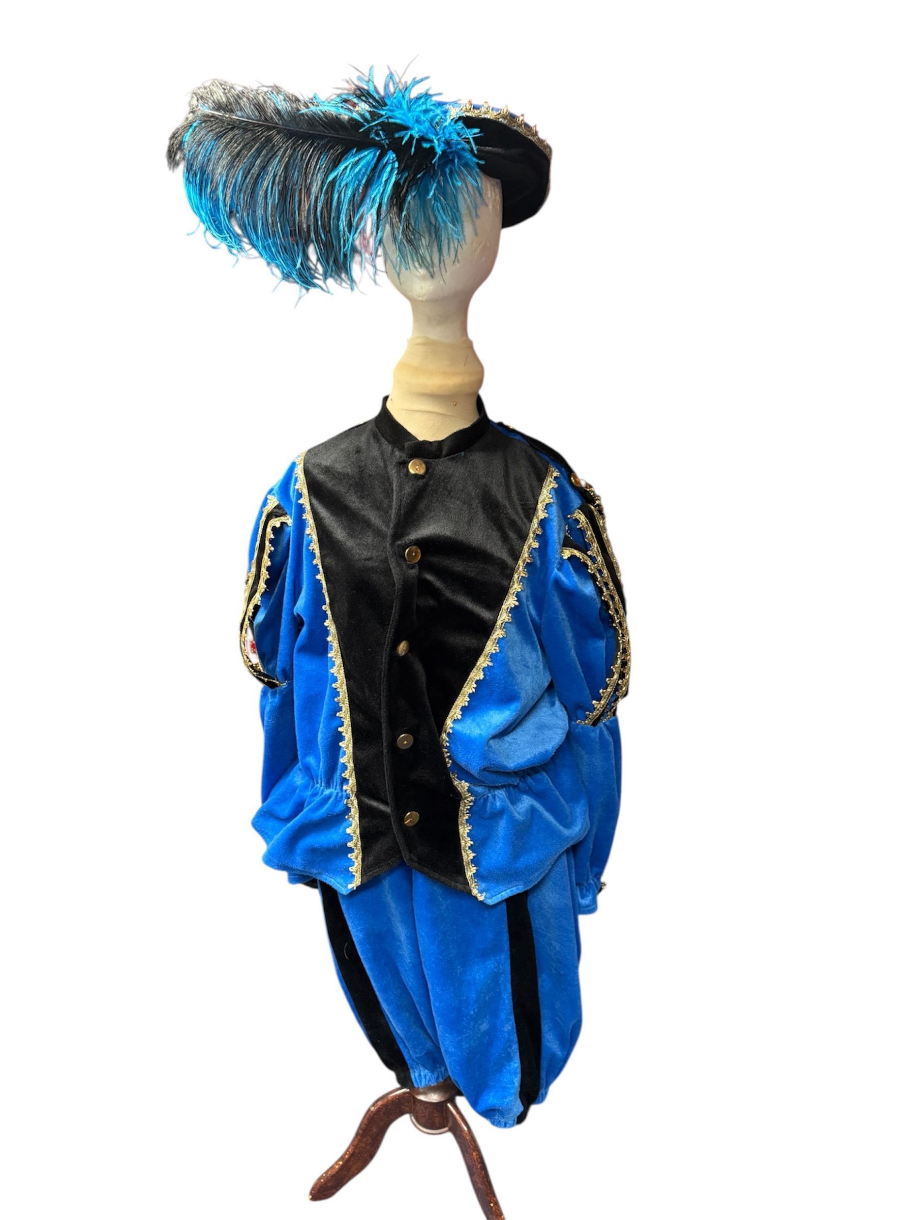 Decoratieve pop in blauw-zwarte kleding met een hoge, gevederde hoofdtooi op een effen achtergrond.