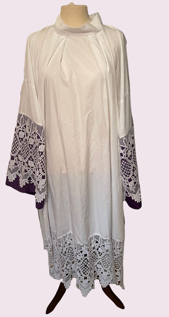 Witte jurk met lange mouwen en zwart-witte manchetten en zoom met patroon, op een paspop.