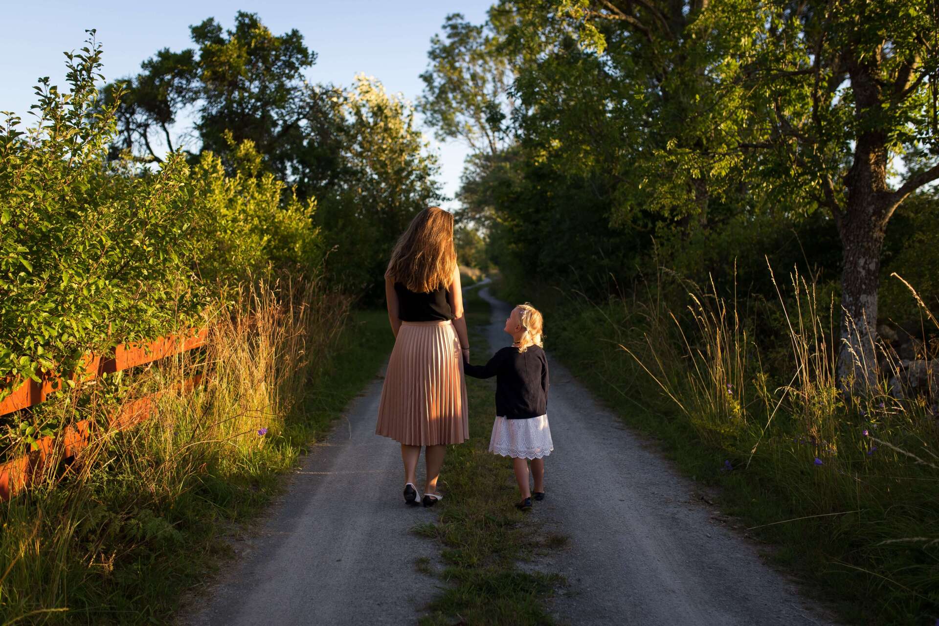 Lady and Child Walking Down Trail in Funeral Service Attire