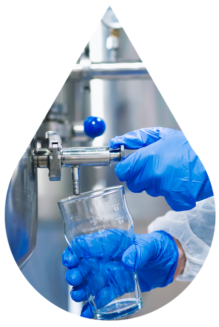 Hands in blue gloves filling glass with liquid from a dispenser at Riverwalk Water in Rosslyn, Pretoria.