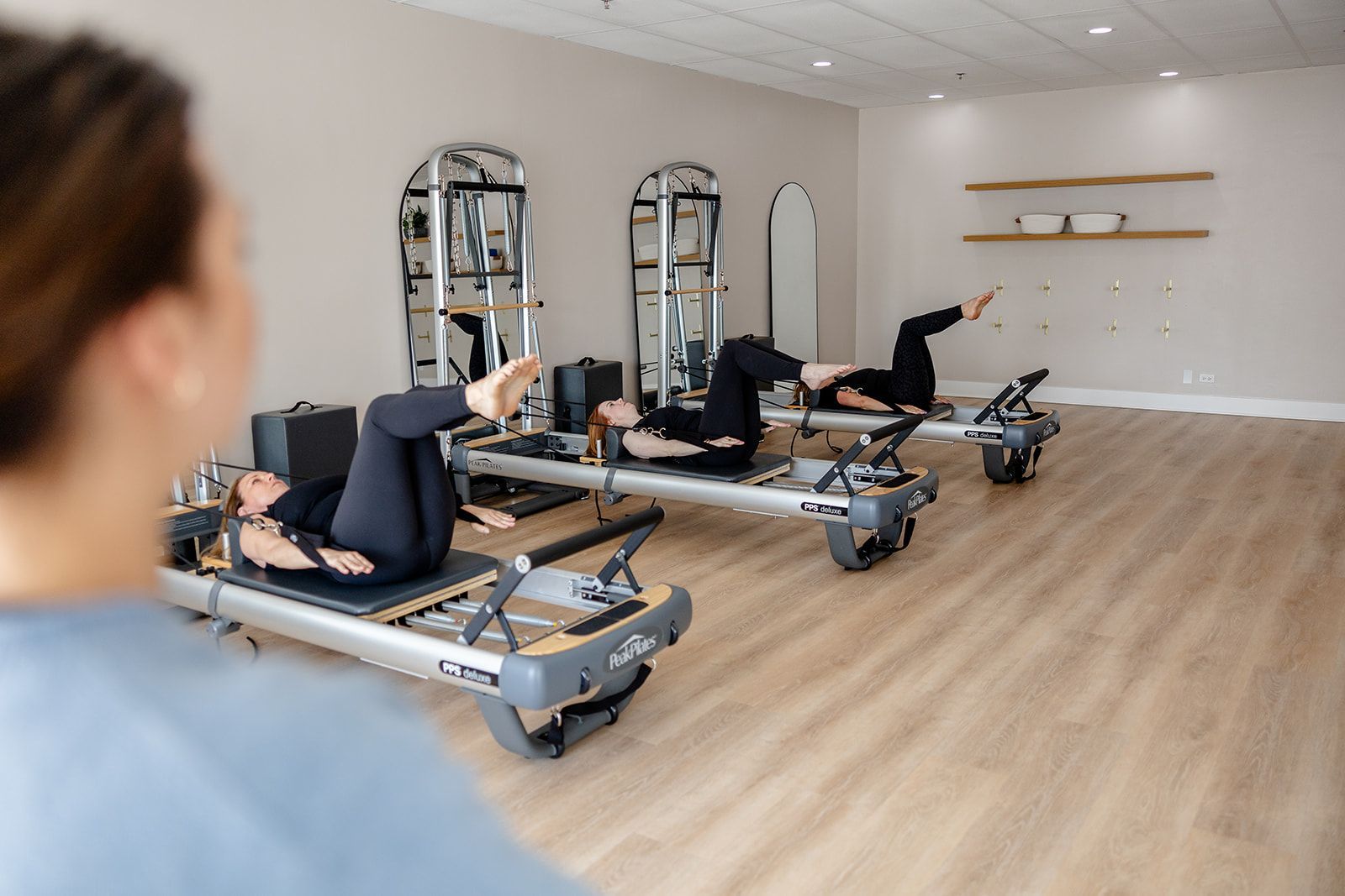 A group of people are doing pilates exercises in a gym.