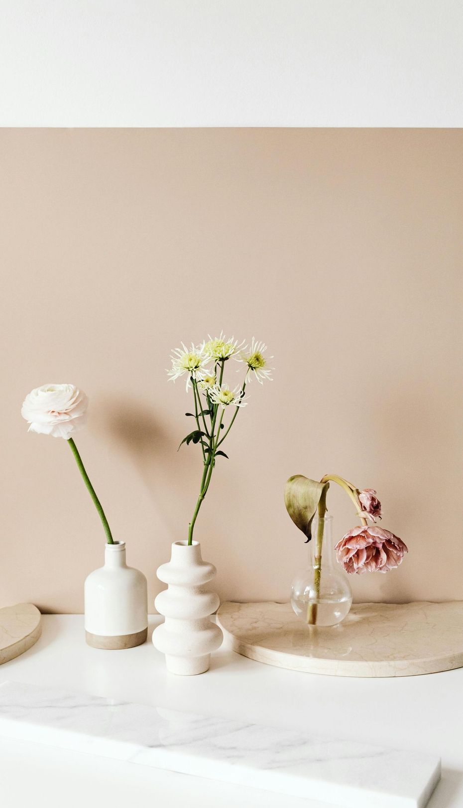 Three vases filled with flowers are sitting on a table.