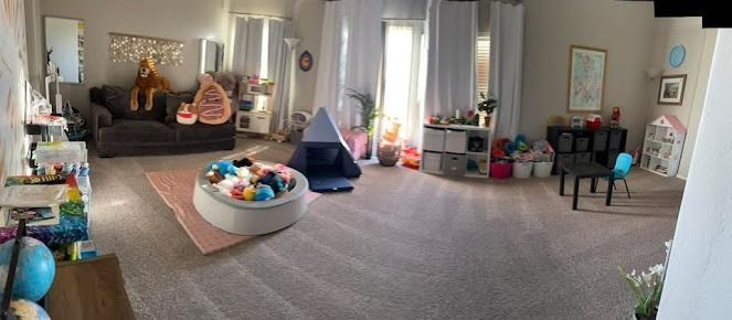 A spacious playroom with a sofa, ball pit, and toys; a child's haven in a light-filled room.