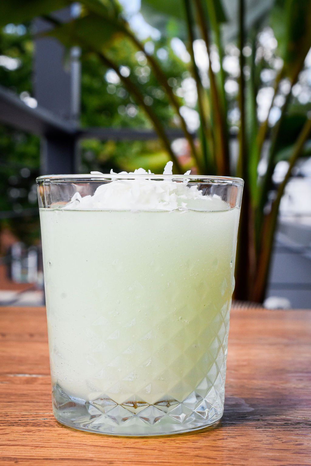 a close up of a drink in a glass on a wooden table .