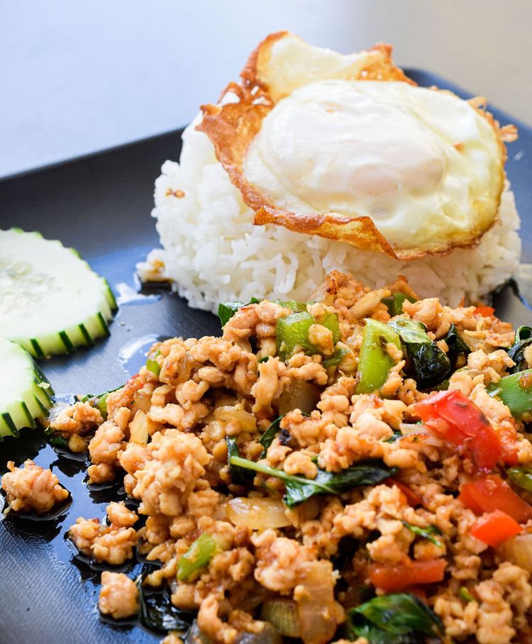 a plate of food with rice and a fried egg on top .