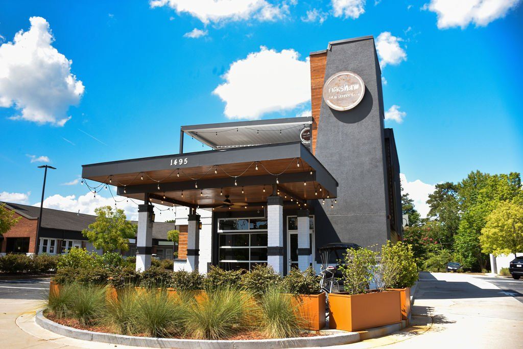 a large building with a lot of plants in front of it .
