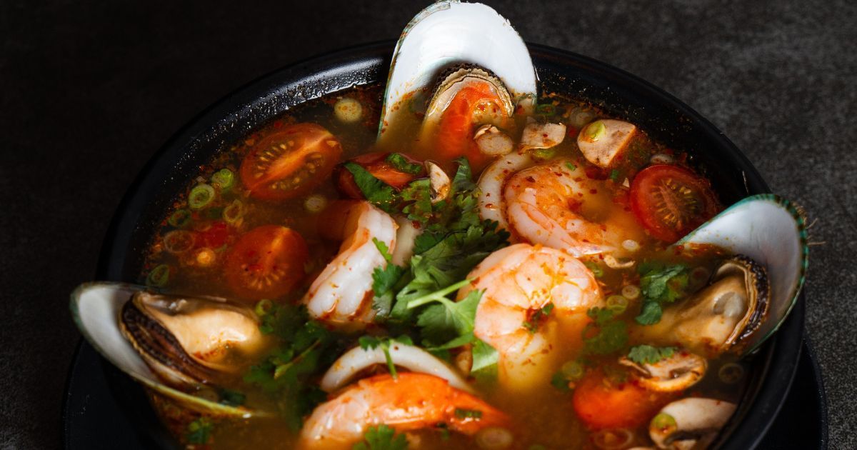 Spicy Thai seafood soup with shrimp, mussels, cherry tomatoes, mushrooms, and herbs served at Rickshaw Thai Street Food in Alpharetta.