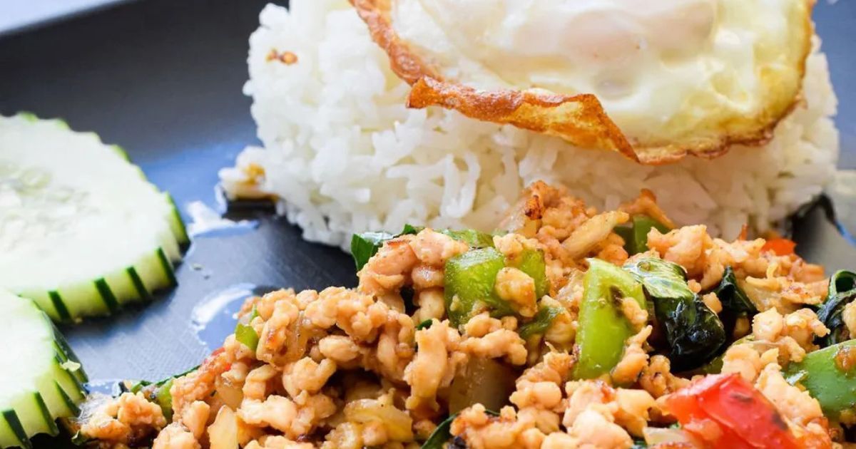 A close up of a plate of food with rice and eggs on a table.