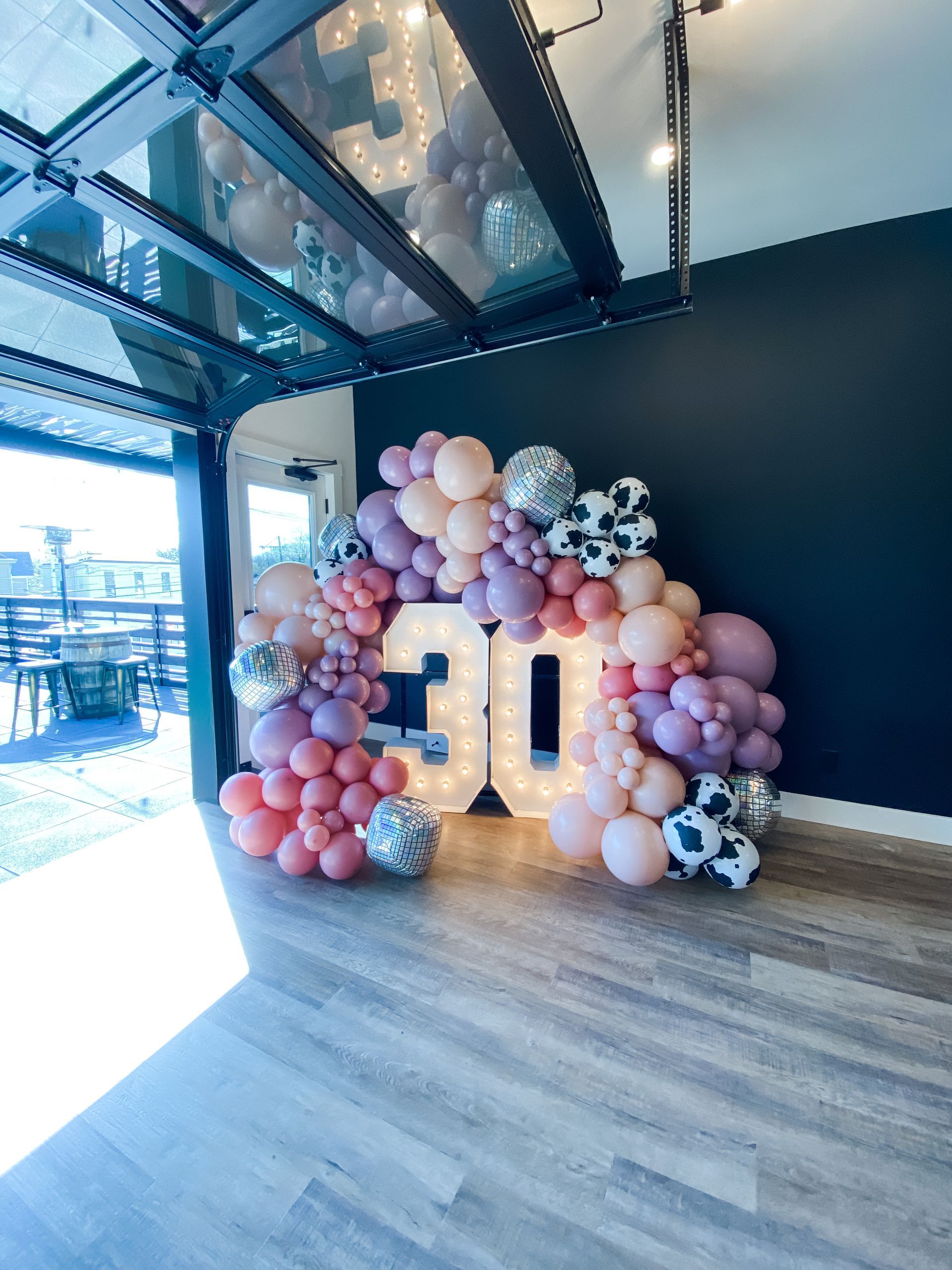 a room filled with balloons and a sign that says 30