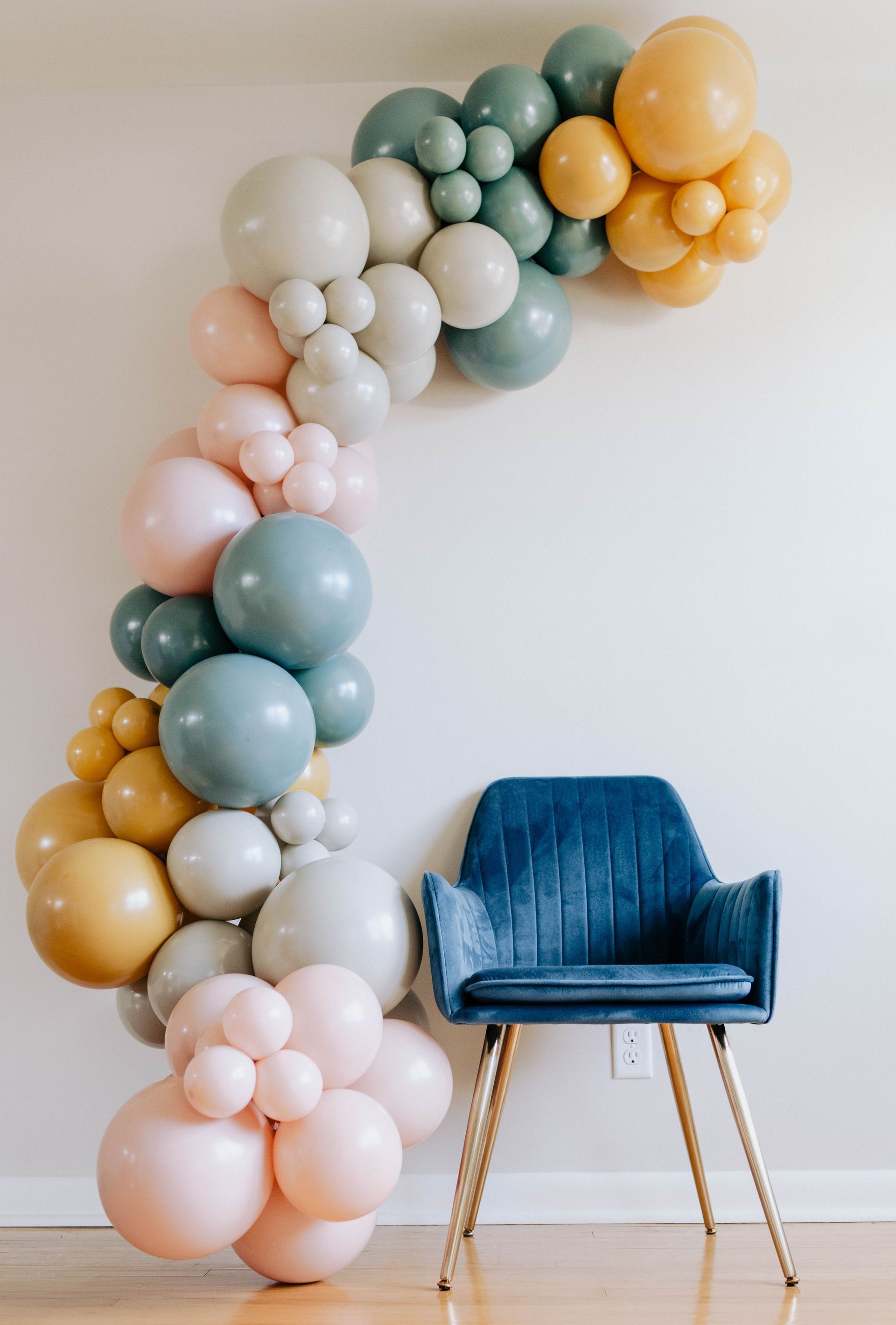 a chair is sitting in front of a wall decorated with balloons