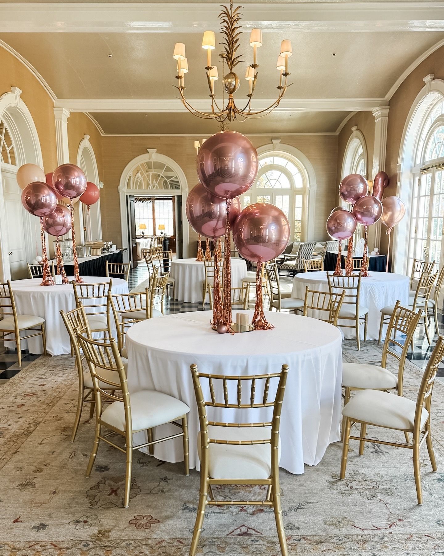 A room filled with tables and chairs decorated with balloons.