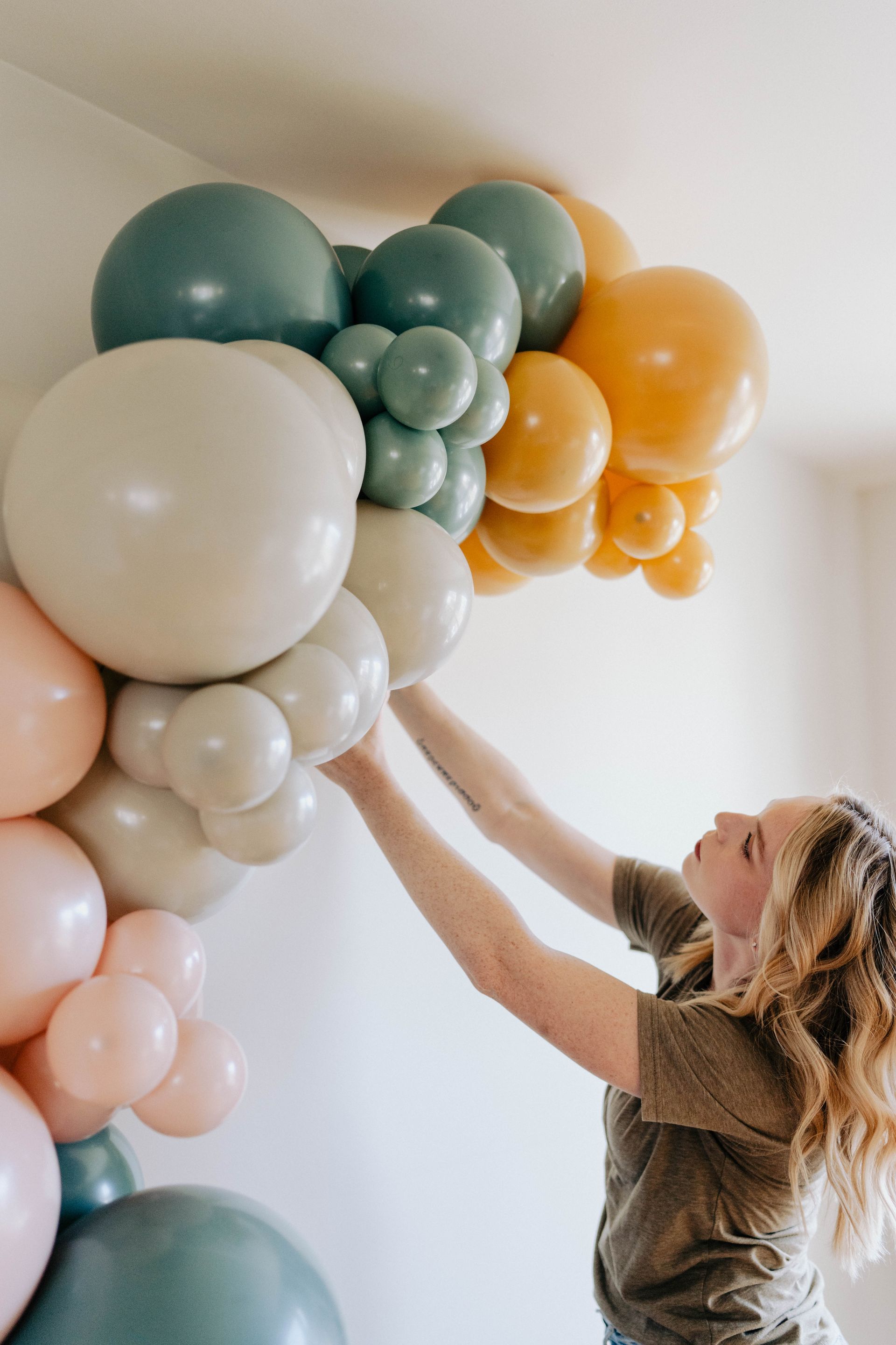 a woman is hanging balloons on a wall
