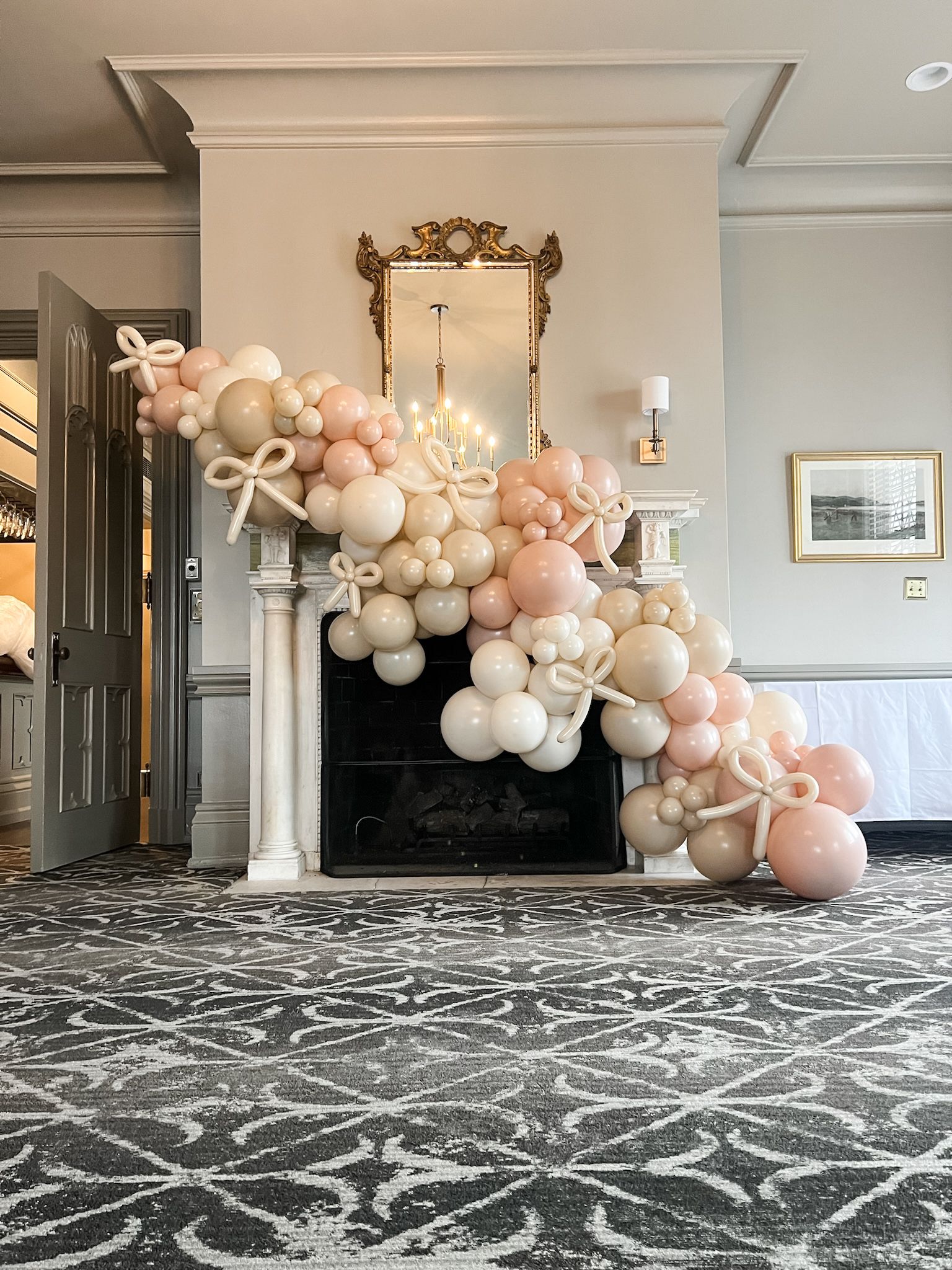 organic balloon garland on fireplace with balloon bows
