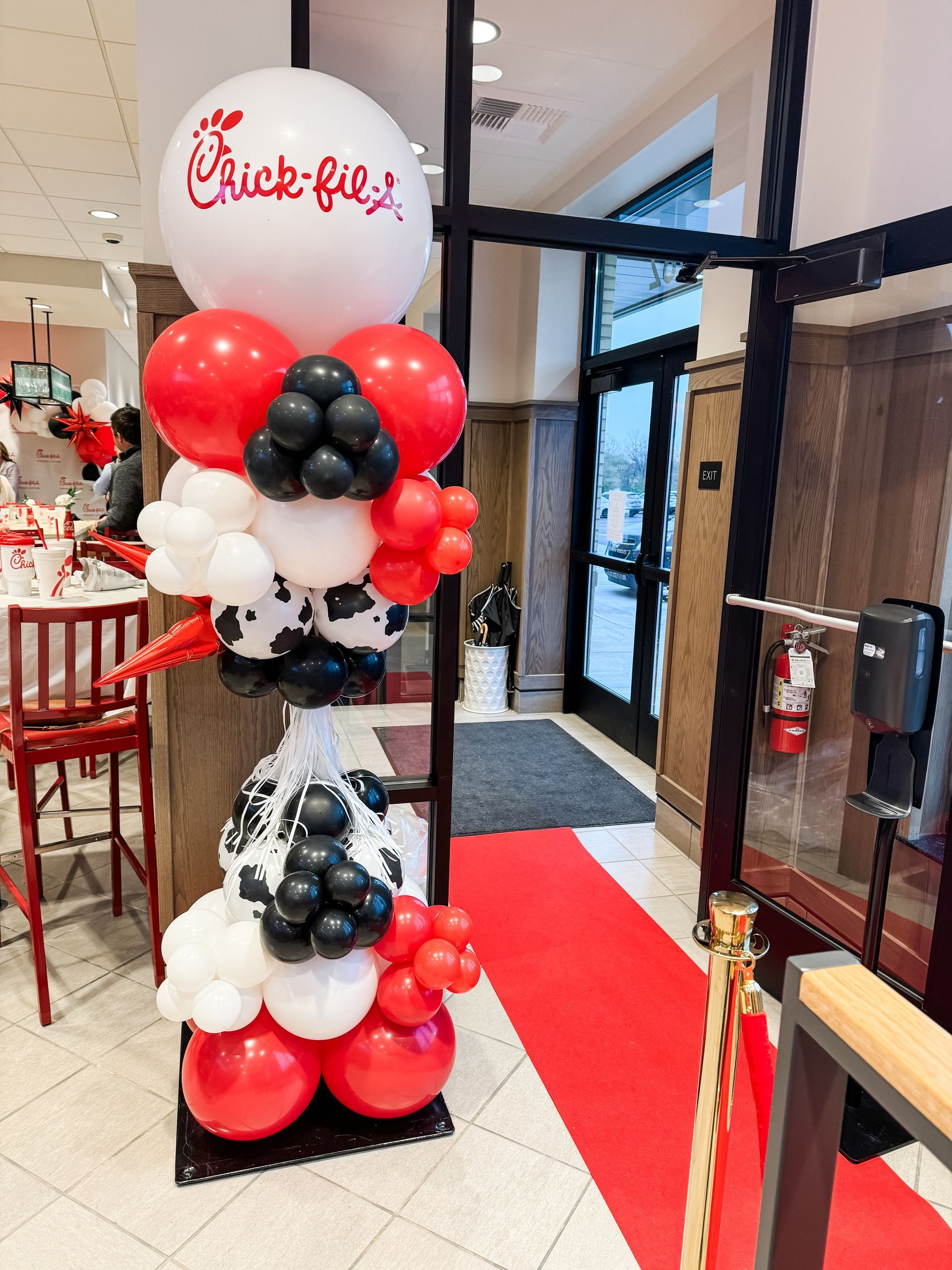 a woman is sitting at a table with balloons in the background