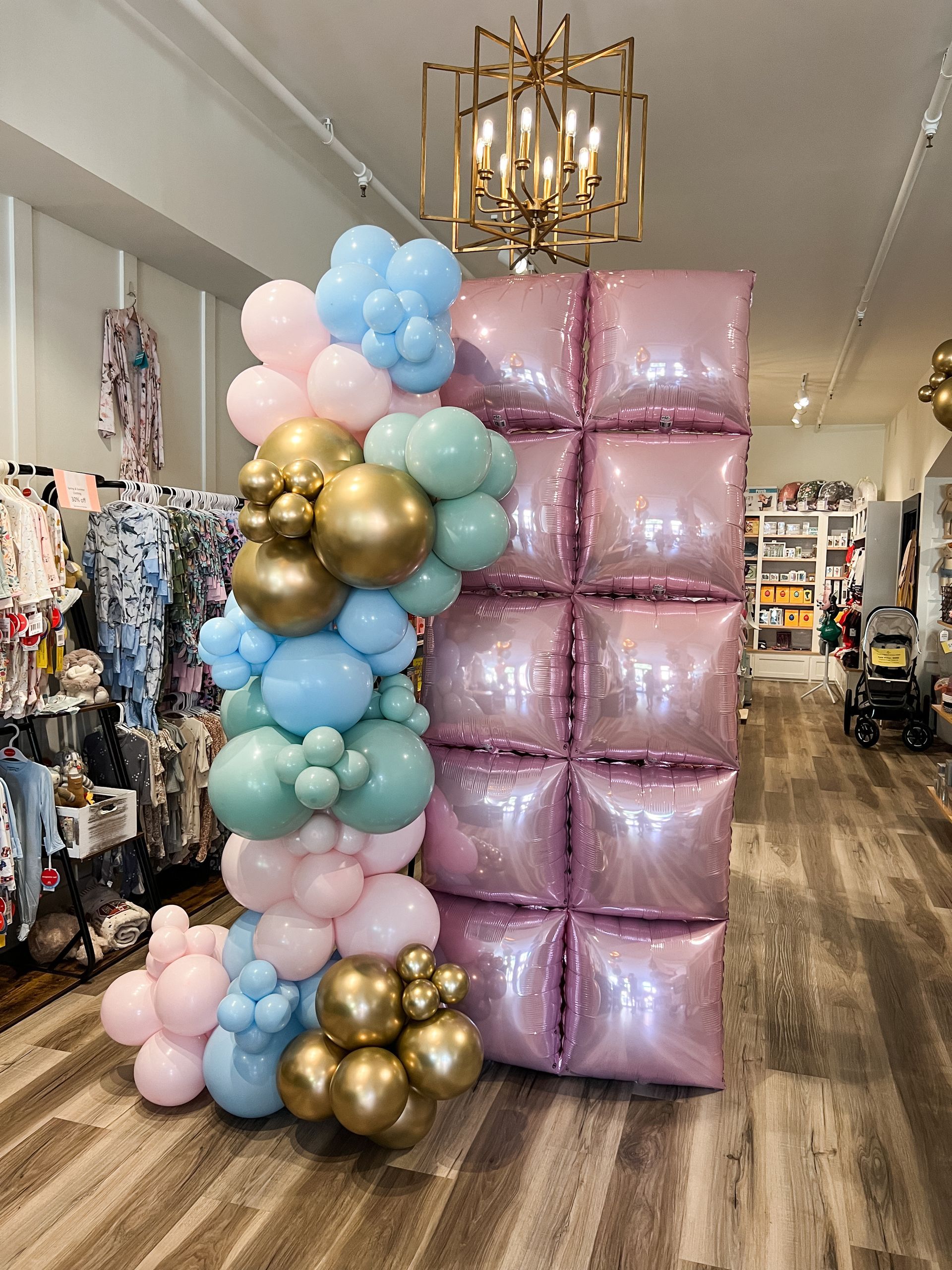 A room filled with balloons and a pink bow for a baby shower.