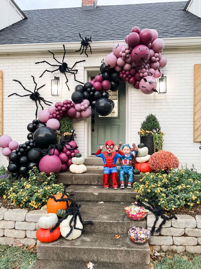 two children are sitting on the steps of a house decorated for halloween