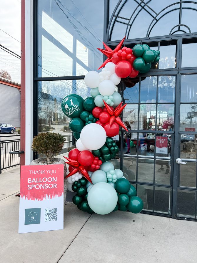 a sign that says balloon sponsor is next to a balloon garland