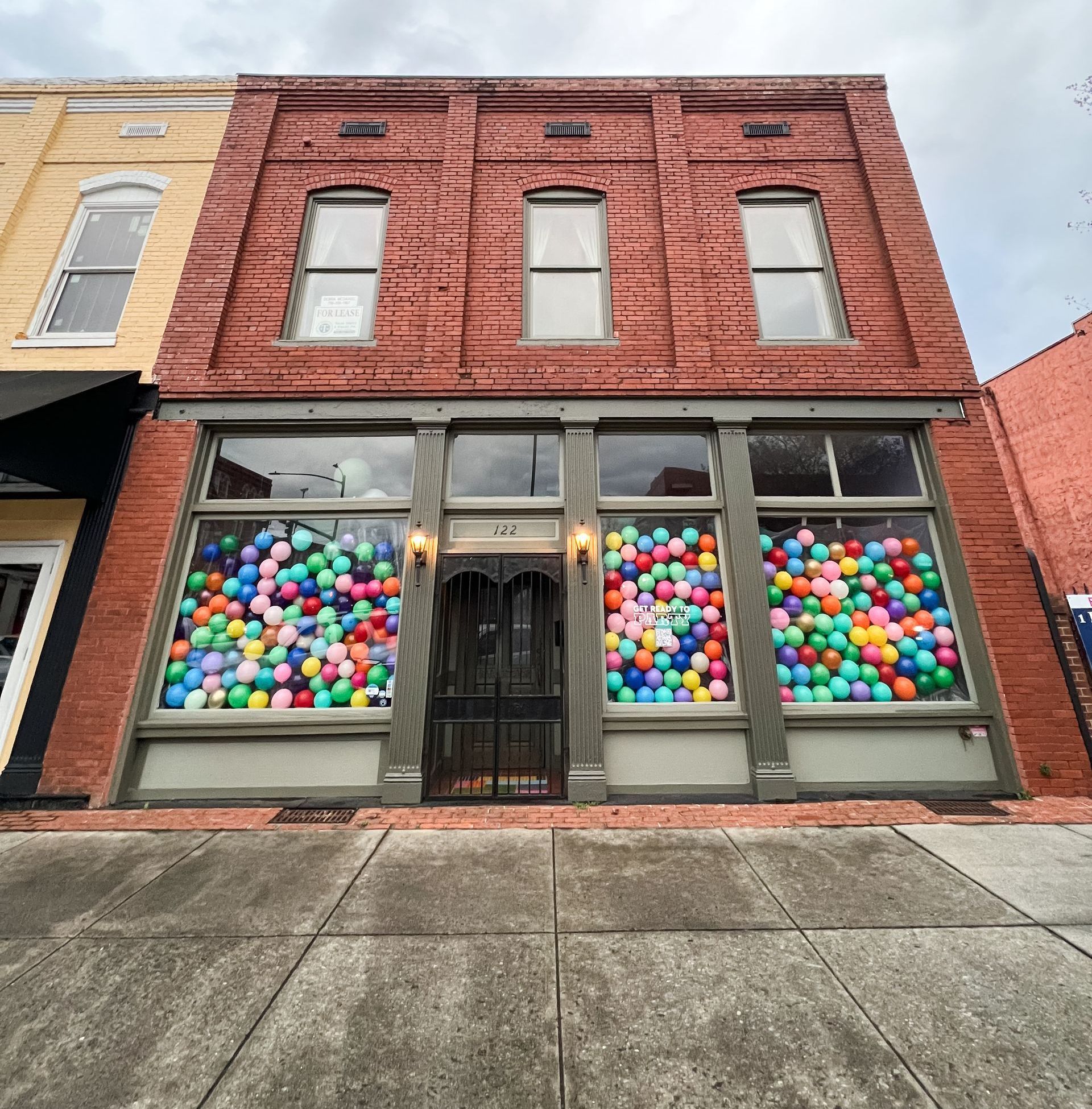 a bunch of balloons are sitting on a table in front of barrels