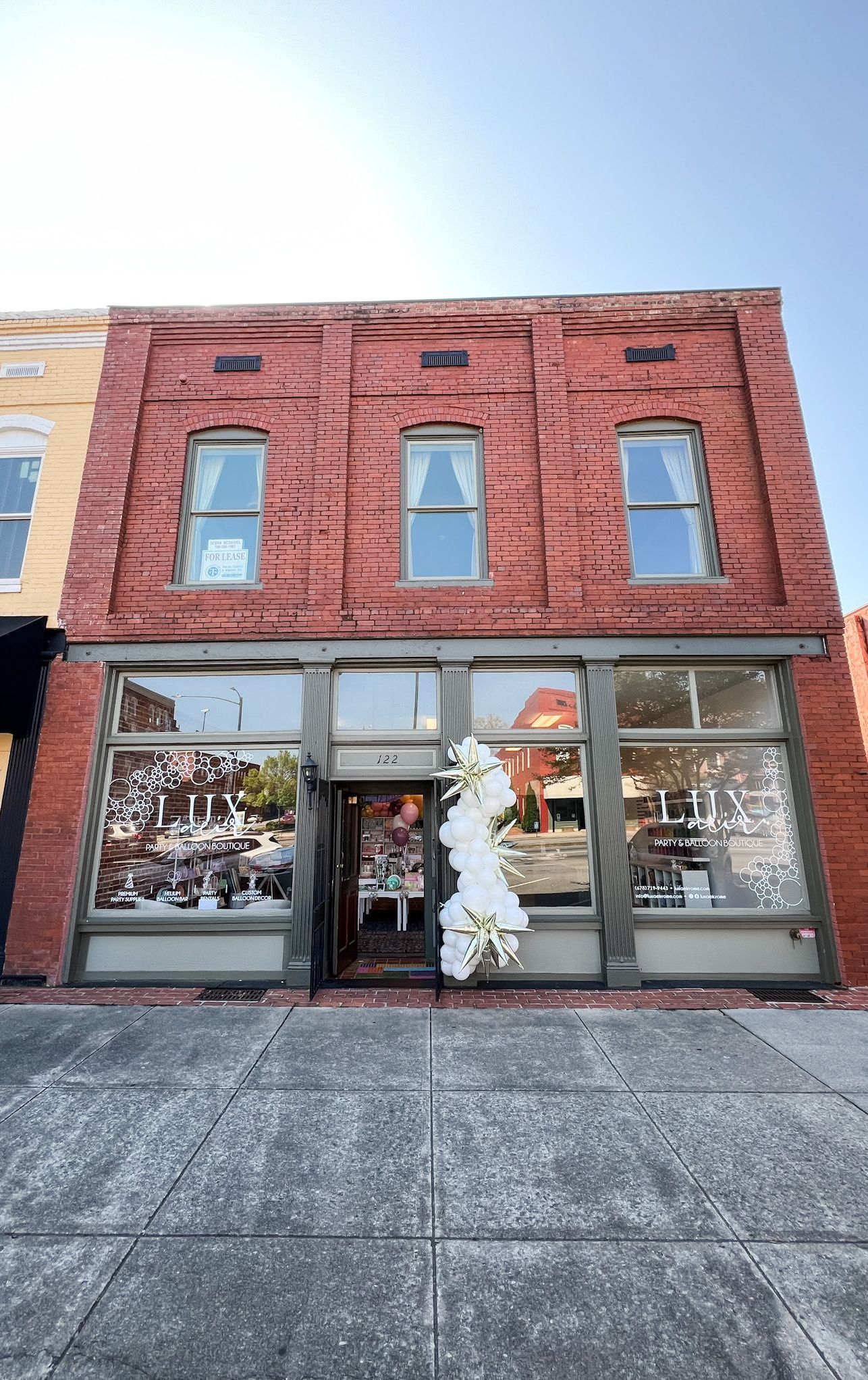 a woman is making a balloon arch in a room