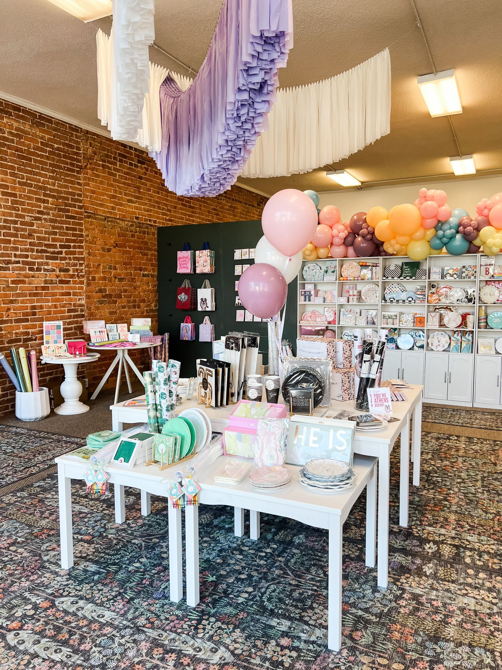 A red , white , and black balloon tower in front of a chick-fil-a restaurant.