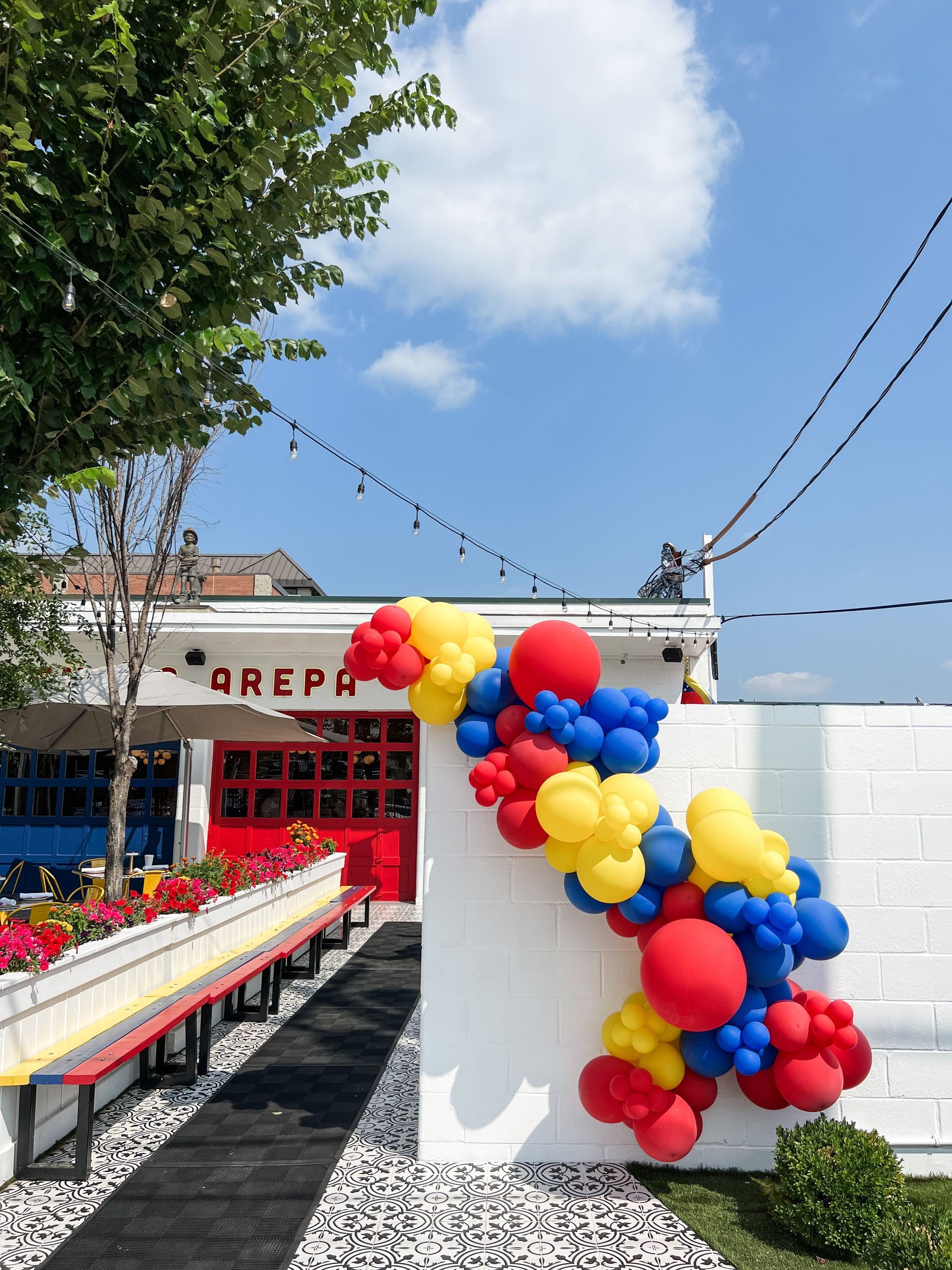 a bunch of balloons are hanging on a wall in front of a building