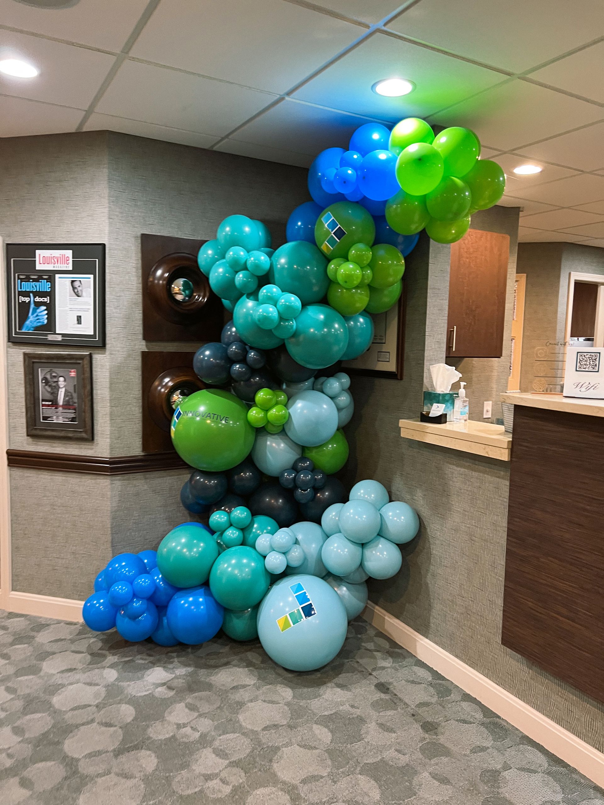 a bunch of balloons are hanging from the ceiling in a room