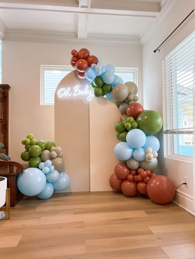 a room filled with balloons and a sign that says oh baby