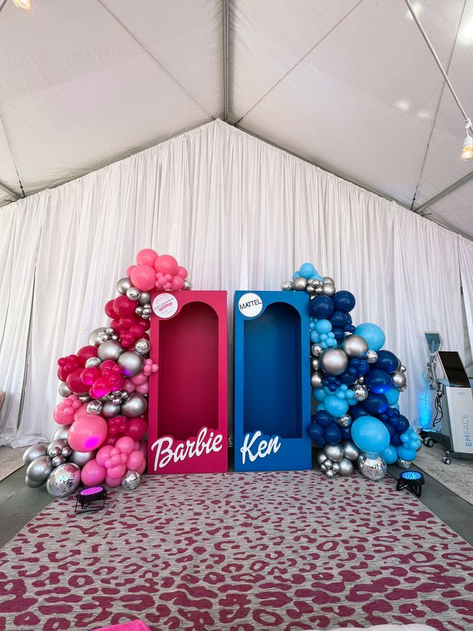 a pink and blue barbie box with balloons around it